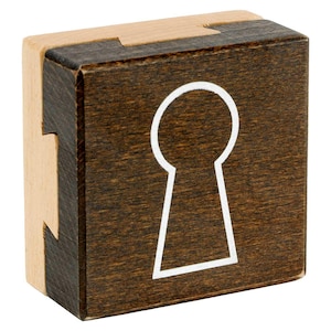 Può includere: Un puzzle a blocchi di legno con un design a forma di buco della serratura marrone scuro su un lato, bordato di bianco. Il puzzle è composto da due pezzi ad incastro, con bordi in legno naturale. Il buco della serratura ha una forma classica.