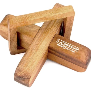 Könnte beinhalten: Ein Holzpuzzle in Form eines Kreuzes mit ineinandergreifenden Teilen. Das Puzzle ist aus hellbraunem Holz gefertigt und hat auf einer Seite ein weißes Logo mit der Aufschrift "LOOSE CHANGE".