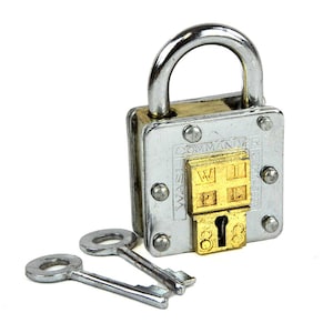 Può includere: Un lucchetto a combinazione argentato con una faccia in ottone e due chiavi. Il lucchetto ha un corpo quadrato con una serratura a combinazione che recita "COMMANDER" e "WASI" sul lato. La serratura a combinazione ha quattro quadranti con le lettere "W", "I", "P" e "L" su di essi.