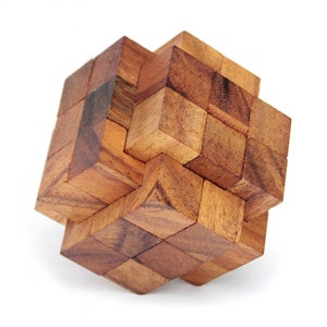 Puede incluir: Un rompecabezas de madera hecho de muchos cubos pequeños que se entrelazan. El rompecabezas tiene la forma de un cubo, y los cubos están dispuestos en un patrón complejo.