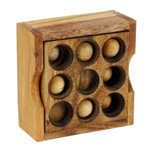 Puede incluir: Caja de rompecabezas de madera con una tapa deslizante y una cuadrícula de nueve agujeros, cada uno con una pequeña bola de madera. La caja está hecha de madera marrón claro con una mancha marrón oscura.