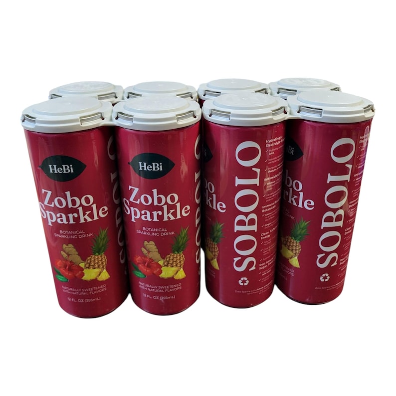 K&ouml;nnte beinhalten: Eine Packung mit sechs roten zylindrischen Dosen des botanischen Erfrischungsgetr&auml;nks "Zobo Sparkle". Jede Dose zeigt eine Ananas- und Ingwer-Illustration. Die Dosen werden von einem wei&szlig;en Kunststofftr&auml;ger zusammengehalten. Der Text "SOBOLO" ist auf der Seite der Dosen aufgedruckt.