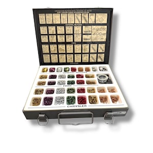 May include: A metal automotive pin kit, open to reveal a white interior with various coloured pins and diagrams. The kit is labelled with "LAB Security Systems Corp." and "3 IN 1 COLOR-CODED AUTOMOTIVE PIN KIT." The kit is for General Motors, Ford, and Chrysler vehicles.