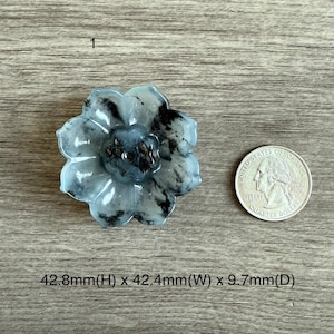 May include: A white and gray jade flower carving with black veins. The flower is approximately 4.28 inches in height, 4.24 inches in width, and 0.97 inches in depth.