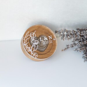 Engraved oak engagement ring box with acrylic lid and rustic linen cushion insert inside.