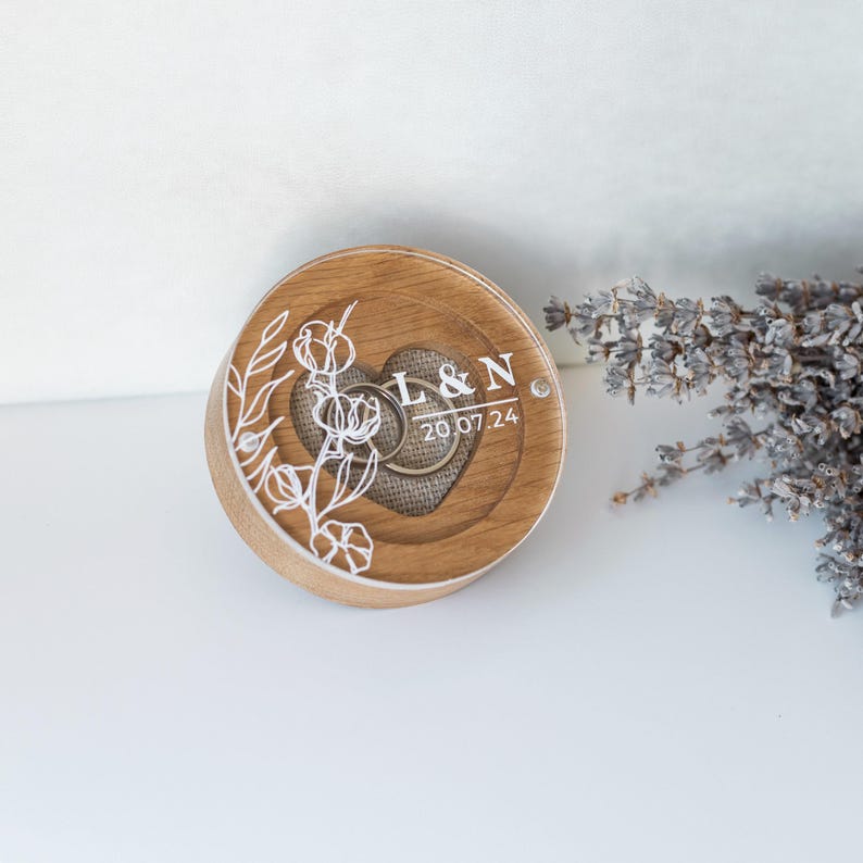 Engraved oak engagement ring box with acrylic lid and rustic linen cushion insert inside.