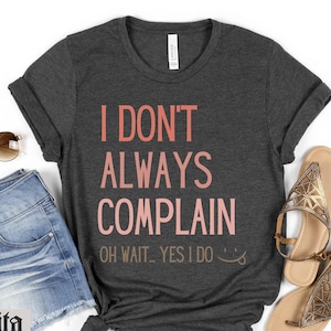 May include: Heather dark gray t-shirt with the text "I don't always complain. Oh wait... yes I do." in pink and white lettering.