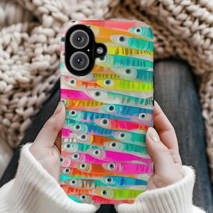 May include: A colourful phone case featuring a pattern of bright, colourful fish. The fish are arranged in rows and have large, black eyes. The case is made from a durable material and is designed to protect your phone from scratches and bumps.