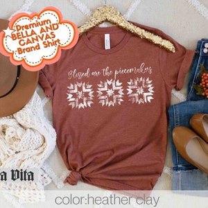May include: A rust-colored t-shirt with the text "Blessed are the peacemakers" and a white geometric design. The shirt is on a hanger and has a tag that says "Premium Bella and Canvas Brand Shirt".