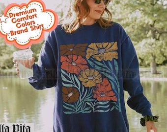 May include: A navy blue sweatshirt with a floral print featuring a variety of colors, including yellow, orange, and red. The text "Stella Vita" is printed on the bottom left corner of the sweatshirt. The text "color: navy" is printed on the bottom right corner of the sweatshirt.