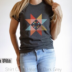 May include: A heather dark grey t-shirt with a colorful geometric star design. The shirt is made of a soft, comfortable material and features a relaxed fit.