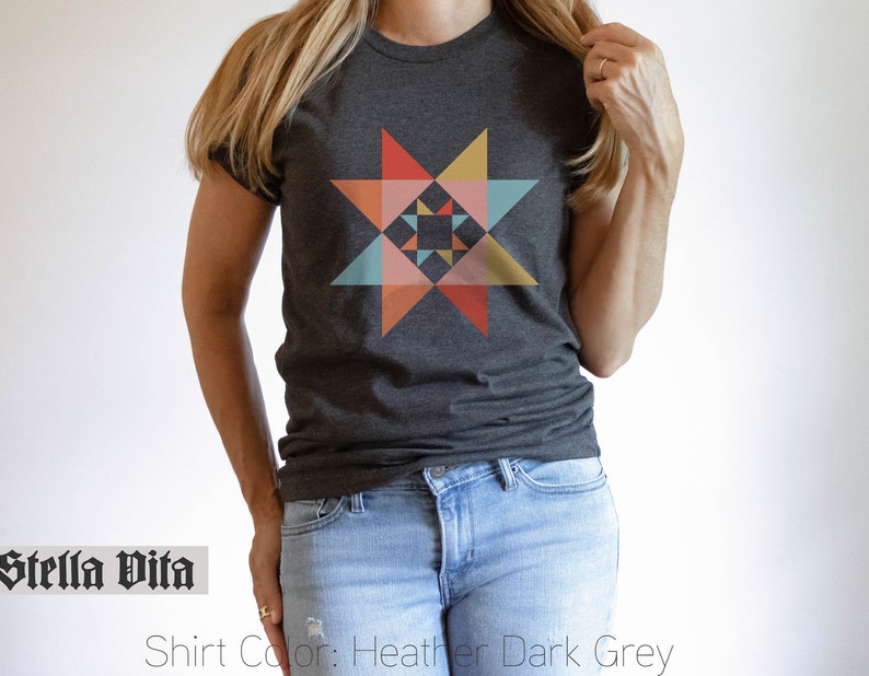 May include: A heather dark grey t-shirt with a colorful geometric star design. The shirt is made of a soft, comfortable material and features a relaxed fit.
