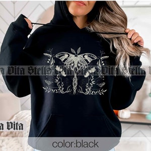 May include: Black hooded sweatshirt with a white graphic of a moth with wings spread and surrounded by flowers and vines. The text "color: black" is printed on the bottom of the sweatshirt.