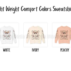 May include: Three sweatshirts in white, ivory, and peachy colors with a butterfly print. The text "Light Weight Comfort Colors Sweatshirt" is at the top of the image.