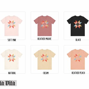 May include: Six different color t-shirts with a colorful geometric star design. The colors are soft pink, heather mauve, black, natural, cream, and heather peach.
