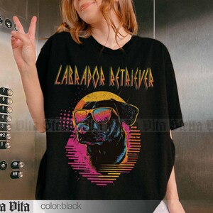 Puede incluir: Camiseta negra con un gr&aacute;fico de un Labrador Retriever con gafas de sol y el texto "Labrador Retriever" en estilo retro.