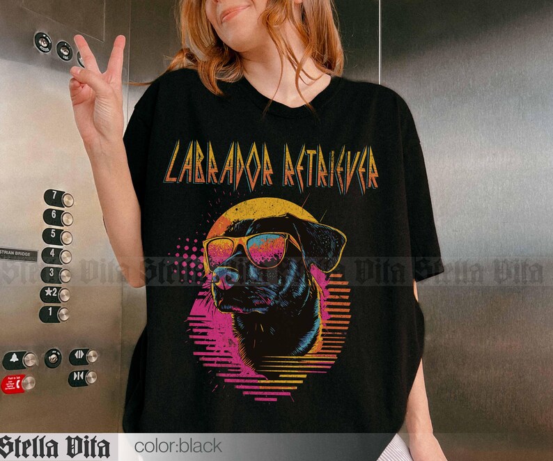 Puede incluir: Camiseta negra con un gr&aacute;fico de un Labrador Retriever con gafas de sol y el texto "Labrador Retriever" en estilo retro.