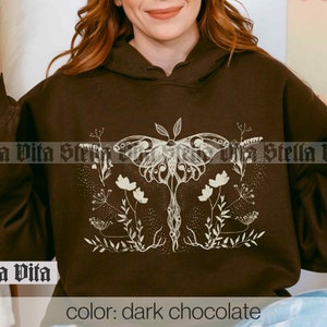 May include: A dark chocolate brown hoodie with a white graphic of a moth and floral design. The text "Stella Vita" is printed on the front of the hoodie.