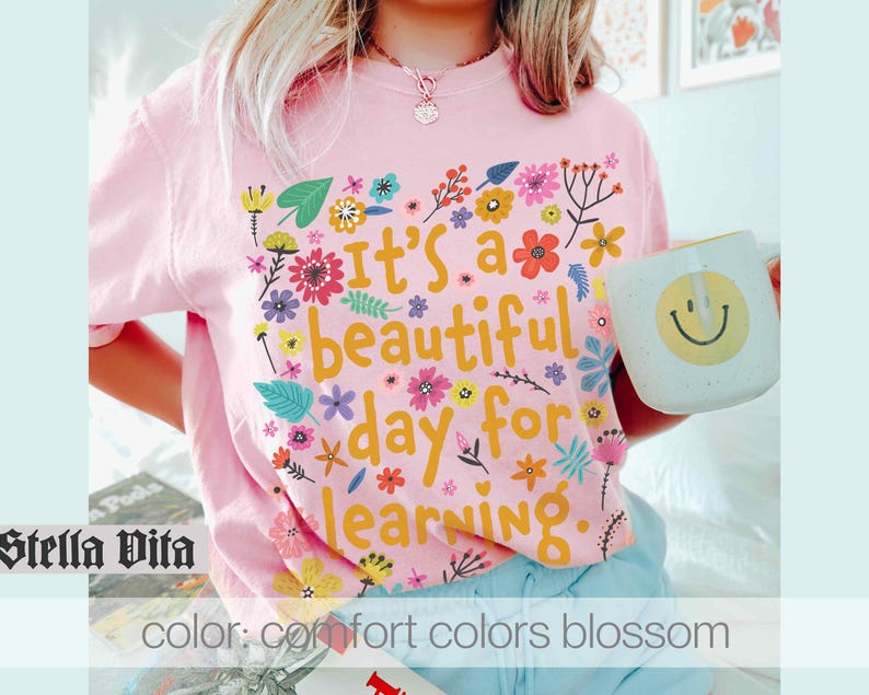 May include: Pink t-shirt with a floral design and the text "It's a beautiful day for learning".