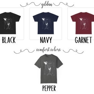 May include: Four t-shirts in different colours: black, navy, garnet, and pepper. Each shirt features a white graphic of a whale with stars.
