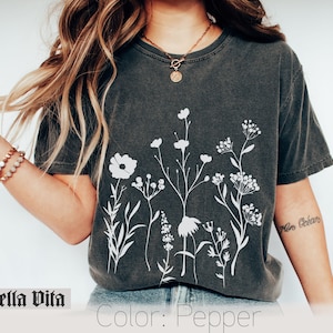 Minimalistisk blommig t-shirt, Komfortfärgad t-shirt, Vit negrös t-shirt med rymdblommor, Vildblommig t-shirt, Boho grafiska t-shirts för kvinnor, Blommig t-shirt bild 1