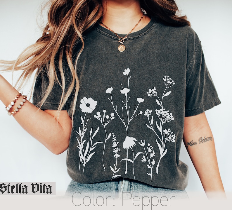 Minimalistisk blommig t-shirt, Komfortfärgad t-shirt, Vit negrös t-shirt med rymdblommor, Vildblommig t-shirt, Boho grafiska t-shirts för kvinnor, Blommig t-shirt bild 1