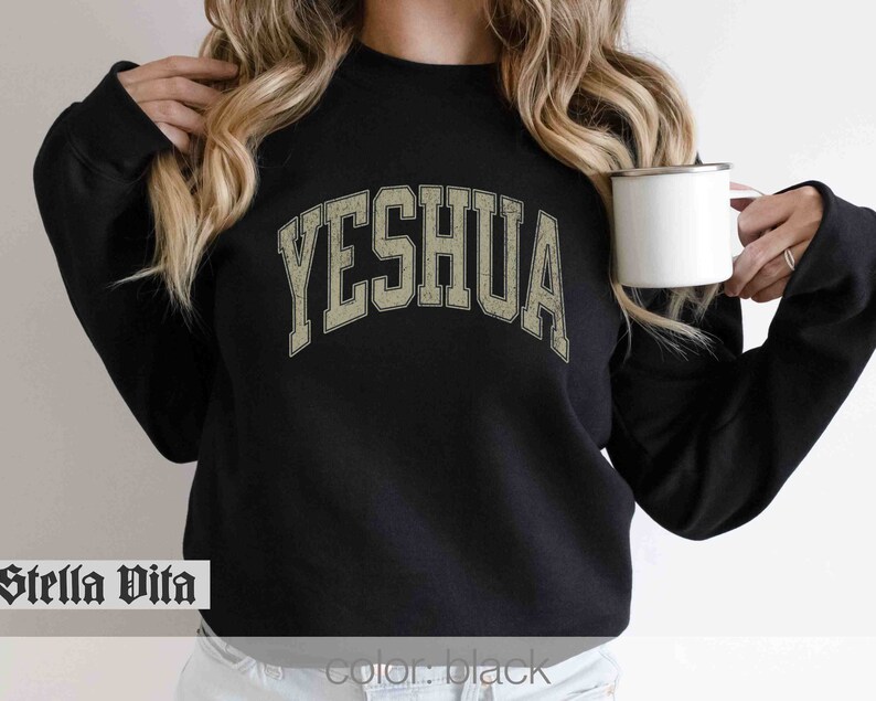 May include: Black sweatshirt with a vintage-style, arched graphic that reads "YESHUA" in a beige color.
