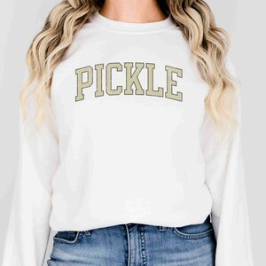 May include: White sweatshirt with the word "PICKLE" printed in a beige, vintage-style font.