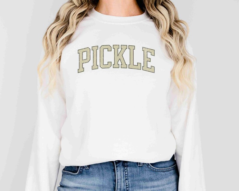 May include: White sweatshirt with the word "PICKLE" printed in a beige, vintage-style font.