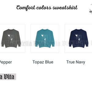May include: Three sweatshirts in different colors: pepper, topaz blue, and true navy. Each sweatshirt features a white graphic of a whale with stars. The text "Stella Vita" is printed on the bottom of the image.
