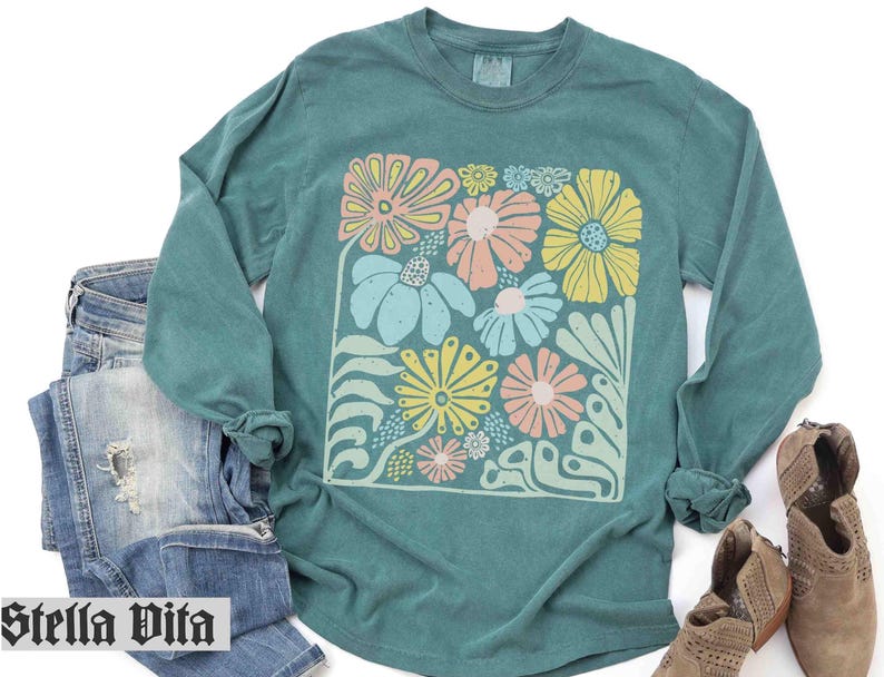 Peut inclure: Chemise &agrave; manches longues turquoise avec un imprim&eacute; floral color&eacute;. L'imprim&eacute; pr&eacute;sente une vari&eacute;t&eacute; de fleurs dans des tons de rose, jaune et vert.