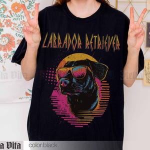 Puede incluir: Camiseta negra con un gr&aacute;fico retro de un Labrador Retriever con gafas de sol y el texto "Labrador Retriever" en una fuente met&aacute;lica en negrita.