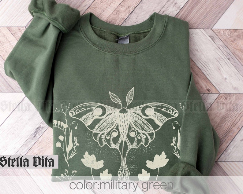 May include: A green sweatshirt with a white print of a moth and flowers. The text "color: military green" is printed below the image.