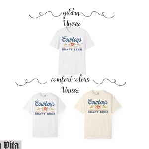 May include: White, light beige, and white t-shirts with the text "Cowboys DRAFT BEER" in blue and red. The shirts are labeled "gildan Unisex" and "comfort colors Unisex". The Stella Vita logo is in the bottom left corner.