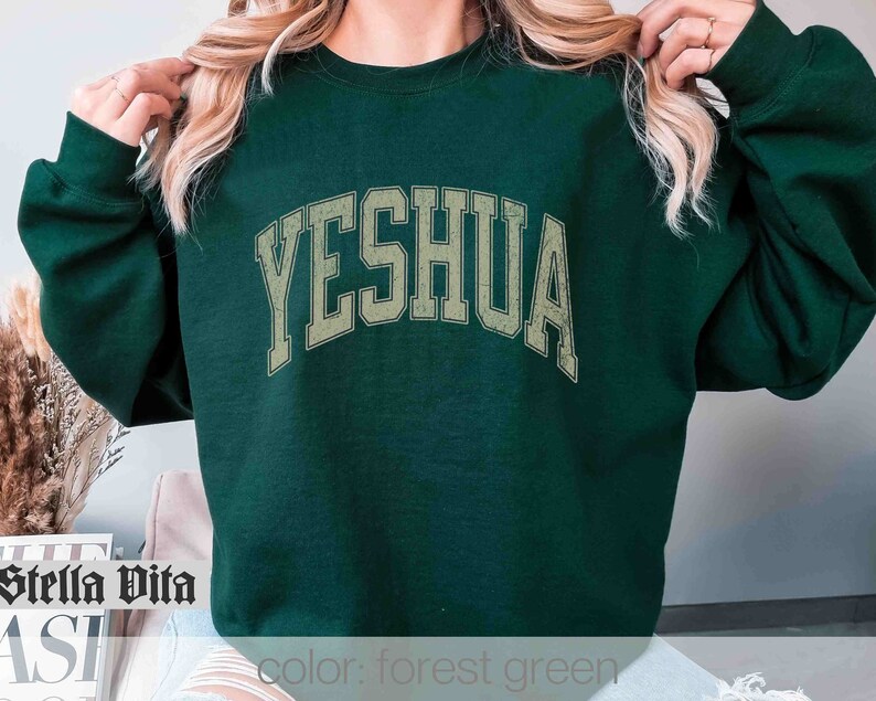 May include: Forest green sweatshirt with the word "YESHUA" printed in a vintage style font.