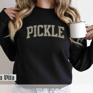 May include: Black sweatshirt with the word "PICKLE" printed in a vintage-style font in beige.