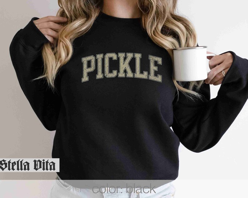 May include: Black sweatshirt with the word "PICKLE" printed in a vintage-style font in beige.