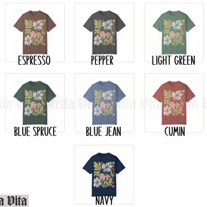 May include: A collection of t-shirts featuring a floral design in various colors, including espresso, pepper, light green, blue spruce, blue jean, cumin, and navy.