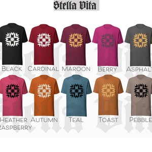 May include: Ten different color t-shirts with a white geometric design on the front. The colors are black, cardinal, maroon, berry, asphalt, heather raspberry, autumn, teal, toast, and pebble.