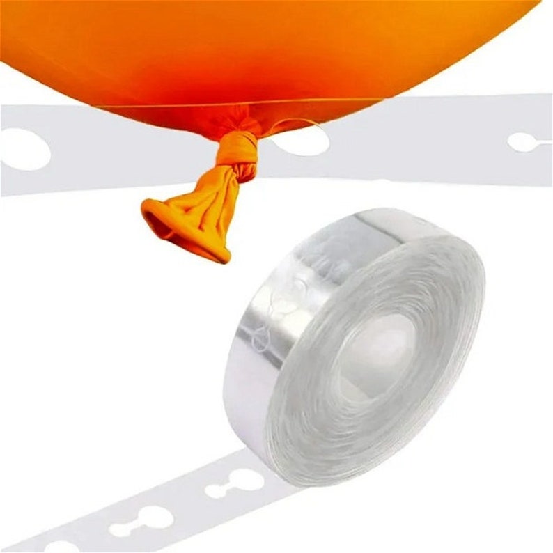 May include: A roll of clear balloon tape with a dispenser. The tape has evenly spaced holes for attaching balloons. A single orange balloon is attached to the tape.
