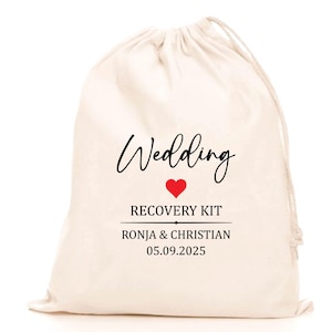 Könnte beinhalten: Ein cremefarbener Kordelzugbeutel mit dem Wort "Wedding" in eleganter schwarzer Schrift. Darunter sind ein rotes Herz und die Worte "RECOVERY KIT" aufgedruckt. Die Namen "RONJA & CHRISTIAN" und das Datum "05.09.2025" sind ebenfalls aufgedruckt.