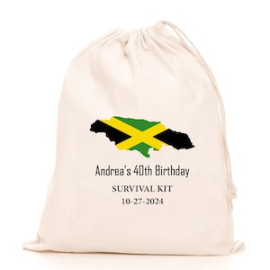 May include: A cream-colored drawstring bag featuring the Jamaican flag in black, yellow, and green. The text "Andrea's 40th Birthday SURVIVAL KIT 10-27-2024" is printed in black below the flag. The bag is made of a soft, natural fabric.