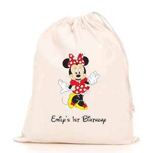 Könnte beinhalten: Eine weiße Baumwoll-Kordeltasche mit einem roten und weißen Polka-Dot-Minnie-Maus-Design. Die Tasche ist mit dem Text "Emily's 1st Birthday" bedruckt.