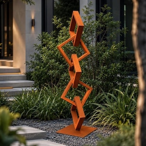 May include: A tall, vertical sculpture composed of four interconnected, hollow, square-shaped metal frames in a rusted orange finish. The structure is mounted on a flat, square metal base, creating a geometric, chain-link design that stands upright.