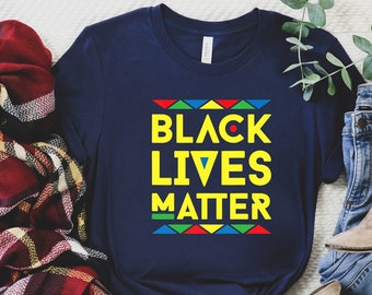 May include: A navy blue t-shirt with the text "Black Lives Matter" in yellow letters. The text is surrounded by a colorful geometric pattern.