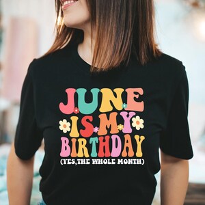 May include: Black t-shirt with a colorful graphic that says "June is my birthday (yes, the whole month)".