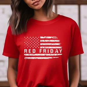 May include: Red t-shirt with a white distressed American flag design and the text "RED FRIDAY" printed on it.