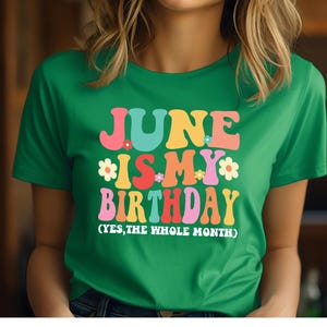 May include: Green t-shirt with the text "June is my birthday (yes, the whole month)" in colorful, retro-style letters.
