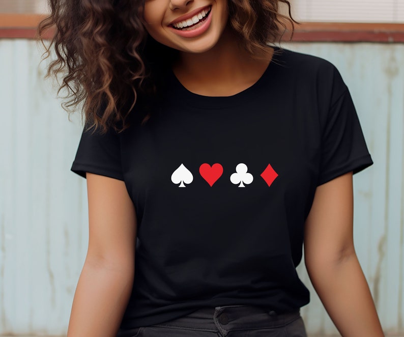 Op de afbeelding: Zwart t-shirt met witte en rode speelkaartsymbolen: schoppen, harten, klaveren en ruiten. De symbolen zijn horizontaal uitgelijnd. Het shirt is gemaakt van een zacht materiaal.