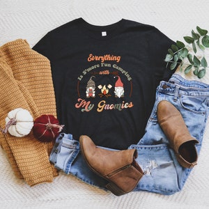 May include: Black t-shirt with a white graphic that says "Everything Is S'more Fun Camping with My Gnomies". The graphic features three gnomes around a campfire.